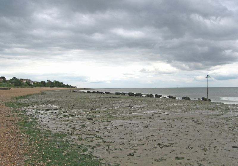  Looking East towards Monkey Beach from Buzz'n.

There is often speculation about the concrete blocks that are by the beach at its western end, near Buzz'n Fleet. They are thought to be an anti-landing craft defence. The concrete blocks had lengths of old tram line from Colchester concreted in, at an angle, and with a point just below the high water mark. [1]
The Lions Talking Magazine No.2 ...
Cat1 Mersea-->Beach Cat2 War-->World War 2